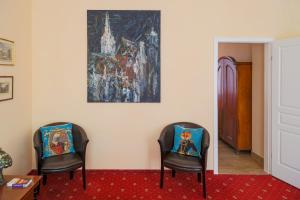 Altwienerhof Aparthotel في فيينا: كرسيين في غرفة مع لوحة على الحائط