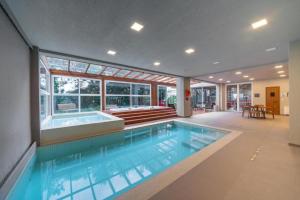 a large swimming pool with a tub in a house at Hotel Laghetto Stilo Borges Gramado RS in Gramado