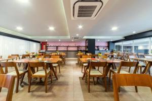 comedor con mesas y sillas de madera en Hotel Laghetto Stilo Borges Gramado RS en Gramado