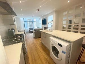 a kitchen and living room with a washer and dryer at Beach House By Sasco in Blackpool