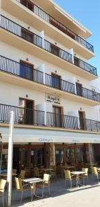 a building with tables and chairs in front of it at Hostal Mayol in Santa Eularia des Riu