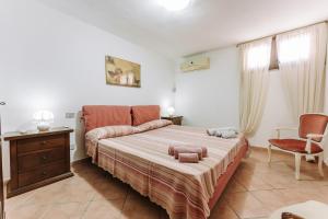 um quarto com uma cama e uma cadeira em Casa vacanze G e B Sardegna em Capitana