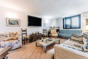 uma sala de estar com dois sofás e uma televisão em Casa vacanze G e B Sardegna em Capitana
