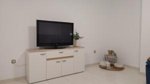 a television sitting on top of a white cabinet at CASA FAMILIAR LA ZUBIA - Granada in La Zubia