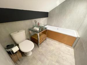 a bathroom with a toilet and a bath tub at Beach House By Sasco in Blackpool