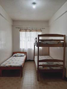 2 Etagenbetten in einem Zimmer mit Fenster in der Unterkunft Sanctuary Transient House in Bacolod City
