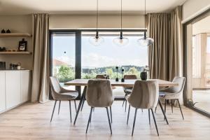a dining room with a table and chairs and a large window at Tiny Villa mit Pool im Salzburger Seenland in Kirchberg bei Mattighofen