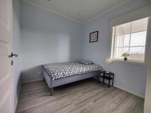 1 dormitorio con 1 cama en una habitación con ventana en ANDY - Perfect location in the heart of Närpes 75 m2 - Sauna - Built in 2023 en Närpiö