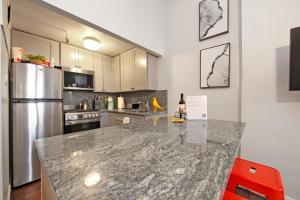 uma cozinha com um balcão de granito e um frigorífico em Serenity Park Slope - Entire Brownstone apt. em Brooklyn
