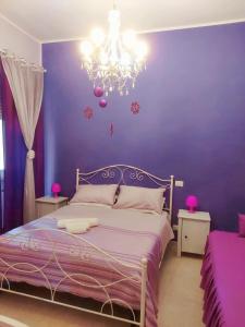 a purple bedroom with a bed and a chandelier at B&B La Casa di Gabry in Rome