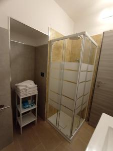 y baño con ducha y puerta de cristal. en pesa apartment B&B, en Ascoli Piceno