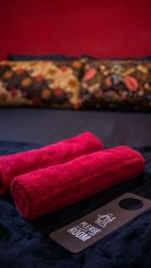 due asciugamani rossi su un tavolo con un cartellino prezzo di House of Lion Hostel a Pantai Cenang