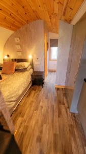 a bedroom with a bed and a wooden floor at Luxurious Family Pod with Garden and Hot tub - The Stag Hoose by Get Better Getaways in Glenluce