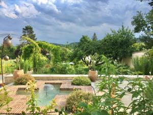 a swimming pool in a garden with plants at Les Grands Jardins Lodge in Giverny