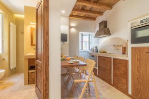 eine Küche und ein Esszimmer mit einem Tisch und Stühlen in der Unterkunft CasaViva - La Dimora del Buttero in Farnese