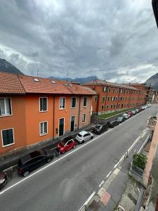 eine Straße mit Autos, die an der Seite eines Gebäudes geparkt sind in der Unterkunft Orchidea Apartment Lecco in Lecco