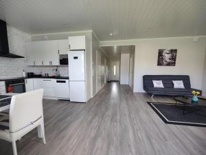 een keuken en een woonkamer met witte apparatuur bij ANDY - Perfect location in the heart of Närpes 75 m2 - Sauna and AC - Built in 2023 in Närpiö +11 foto's