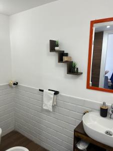 a white bathroom with a sink and a mirror at Napoli studio 106 in Naples