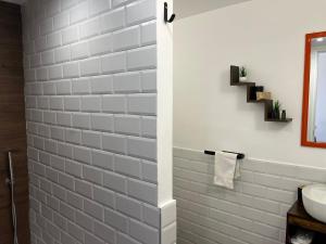 a bathroom with a sink and a white tile wall at Napoli studio 106 in Naples