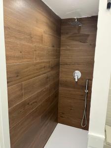 a bathroom with wooden walls and a shower stall at Napoli studio 106 in Naples