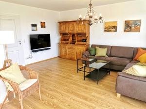 ein Wohnzimmer mit einem Sofa und einem TV in der Unterkunft Landhaus Vogel - helle und lichtdurchflutete Maisonette-Ferienwohnung in Wasserburg