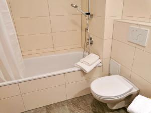 ein Badezimmer mit Toilette und Badewanne in der Unterkunft Landhaus Vogel - helle und lichtdurchflutete Maisonette-Ferienwohnung in Wasserburg + 23 Fotos