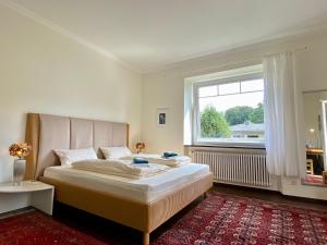 um quarto com uma cama grande e uma janela em Villa Schwanenblick - eine besonderes Feriendomizil mit direktem Seezugang und Slipanlage em Nonnenhorn