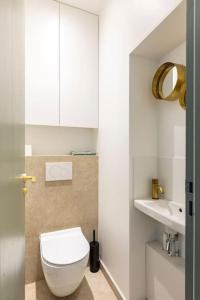ein Badezimmer mit einem weißen WC und einem Waschbecken in der Unterkunft Luxury in the heart of St Germain A/C 3 BR outdoor in Paris