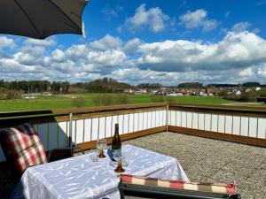 a table with a bottle of wine on a balcony at Ferienwohnung Blumenoase - gemütliche Ferienwohnung zwischen Allgäu und Bodensee in Sigmarszell