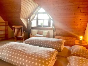 - une chambre avec deux lits, une chaise et une fenêtre dans l'établissement Ferienwohnung Niedan, à Kressbronn am Bodensee