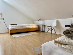 een slaapkamer met een bed, een tafel en een stoel bij Ferienwohnung Seebrise in Wasserburg