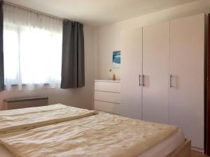 a bedroom with a bed and a white cabinet at Ferienwohnung Fischerpromenade in Kressbronn am Bodensee