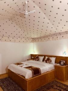 a bedroom with a large bed with a ceiling at Shrinath Desert Camp in Jaisalmer