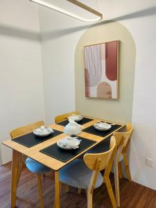 梳邦再也的住宿－Muji Studio USJ，一张餐桌,配有四把椅子和一幅画