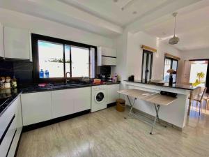 uma cozinha com armários brancos e uma mesa dentro em Dar Selima Hammamet em Hammamet