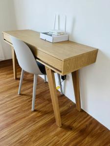 Muji Studio USJ في سوبانغ جايا: مكتب خشبي عليه كرسي وعلبة صندوق