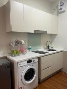een keuken met een wasmachine en een wastafel bij Muji Studio USJ in Subang Jaya