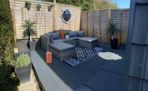 a patio with a couch and chairs on a deck at Willow Nook, near Saundersfoot and Tenby in Saundersfoot