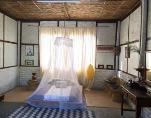 a bedroom with a bed with a mosquito net at Petrichor - Regenerative Living Experience in Gorubathān