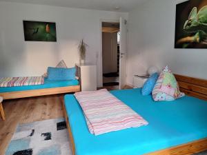 een kamer met 2 bedden met blauwe lakens en een kamer met: bij Schöni´s Zimmer in Abstatt