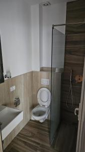 uma casa de banho com um WC e uma cabina de duche em vidro. em Hotel Marigona em Shëngjin