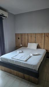 uma cama com uma cabeceira de madeira num quarto em Hotel Marigona em Shëngjin
