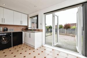 a kitchen with a large sliding glass door with a patio at 3 Bed Home for Contractors & Relocators with Parking, Garden & WiFi 30 mins to Alton Towers in Stoke on Trent