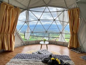 une chambre avec une grande fenêtre dans une tente en forme de dôme dans l'établissement เหนือดอย แคมป์ปิ้ง ( Nuea Doi Camping ), à Ban Dong