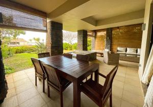 a wooden table and chairs in a living room at Private Beach 5-star Villa, Golf & Luxe in Centre de Flacq