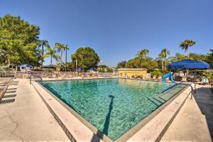 uma piscina num resort com cadeiras e guarda-sóis em Port Charlotte Home with Pool Access 10 Mi to Beach! em North Port
