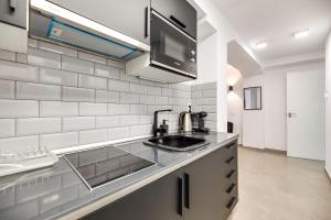 eine Küche mit Spüle und Mikrowelle in der Unterkunft Parkview Apartments 2 in Marbella