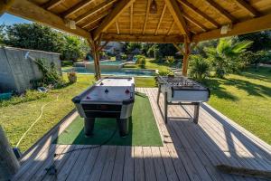 a pool table and a grill on a deck at Gîte M in Codognan