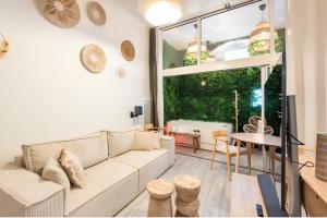 a living room with a couch and a table at Secret Jungle Bordeaux Chartrons - Hyper-Centre Jacuzzi Bain Balnéo & Home cinéma in Bordeaux +8 photos