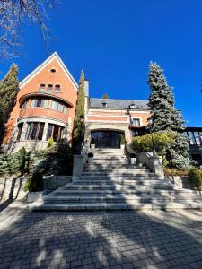 a large brick building with stairs leading up to it at Palacio de Miraflores in Miraflores de la Sierra